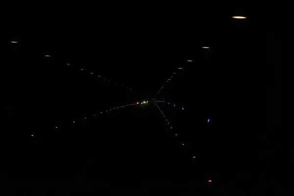 トンネル内のランプや車からの光 暗闇の中の提灯からの光 多色ドットの黒の背景 — ストック写真