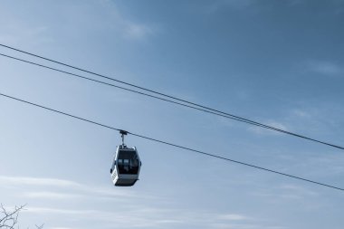 Kablo yolu mavi gökyüzüne karşı. Zarif taksiler çelik ipler boyunca hareket ederler. İyi günler. Güneşli. Gürcistan, Tiblis.