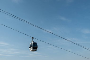 Kablo yolu mavi gökyüzüne karşı. Zarif taksiler çelik ipler boyunca hareket ederler. İyi günler. Güneşli. Gürcistan, Tiblis.