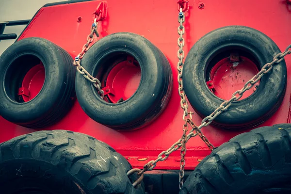 Old car tires on board a ship. Rubber wheels protect the boat from impact. Steel lining of the side of the tugboat.