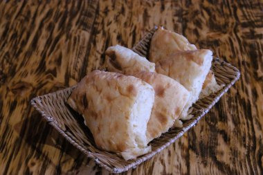 Masadaki sepetteki pita ekmeği parçaları. Lavaş, buğday unundan yapılmış ince bir tortilla şeklinde mayalanmamış beyaz ekmektir ve çoğunlukla Kafkaslar, İran, Afganistan ve Küçük Asya 'nın diğer bölgeleri arasında dağıtılır..