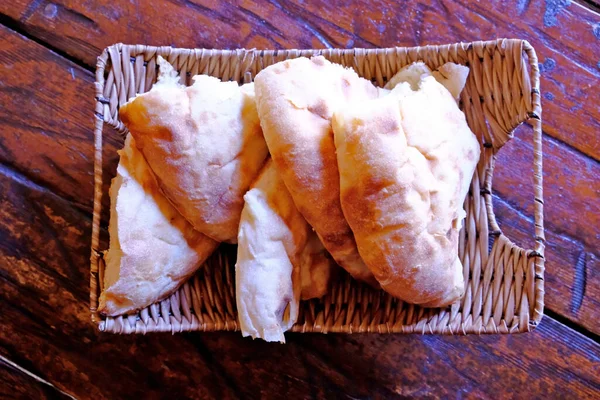 Pieces of pita bread in a basket on a table. Lavash is unleavened white bread in the form of a thin tortilla made of wheat flour, distributed mainly among the peoples of the Caucasus, Iran, Afghanistan and other regions of Asia Minor.