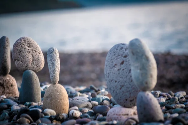 Summer is coming soon in a pandemic. Deserted city beach on the Black Sea. Sculptures of stones, a symbol of people. Stone people. Imitation of lovers. Art installation from pebbles. Meditation at sea.