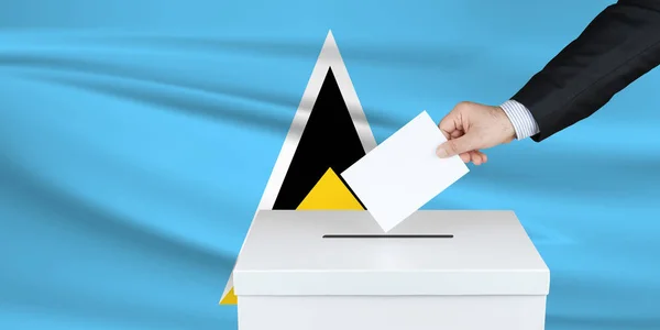 圣卢西亚的选举 把他的选票放进投票箱的人的手 背景上飘扬的圣卢西亚国旗 — 图库照片