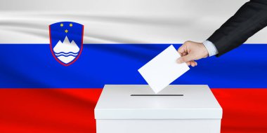 Slovenya 'da seçim. Oylarını sandığa koyan adamın eli. Arka planda Slovenya bayrağı salladı.                               