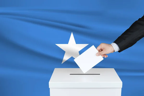 索马里的选举 把他的选票放进投票箱的人的手 背风飘扬的索马里国旗 — 图库照片