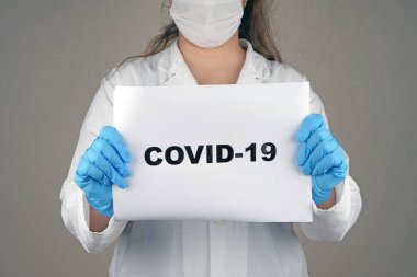 Doktor elinde covid-19 tutuyor.