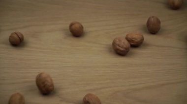 Cevizler Düşer ve Ekranı Doldur. Ahşap zemine düşen organik cevizler. Yavaş çekim.