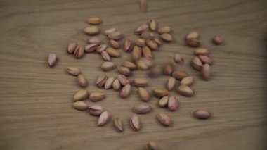 Organik Pistachio tahta arka planda yuvarlanıyor. Yavaş çekim.