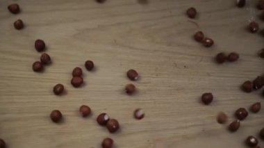 Organik fındık çekirdeği ahşap zemine düşüyor. Yavaş çekim.