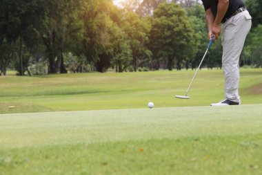 Golfçü güzel golf sahasında akşam golf oynuyor.