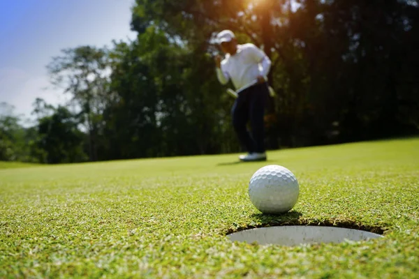 Homályos golfozó golfozik az esti golfpályán, a nap s — Stock Fotó