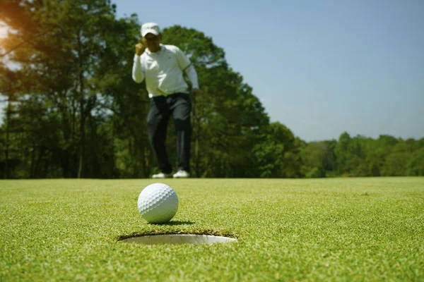 Golfista desfocado jogando golfe no campo de golfe da noite, no sol s — Fotografia de Stock