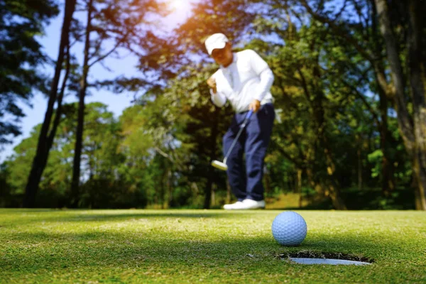 Homályos golfozó golfozik az esti golfpályán, a nap s — Stock Fotó