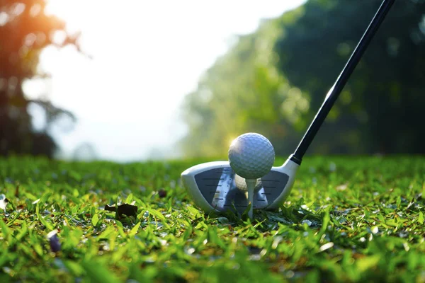 Clube de golfe desfocado e bola de golfe perto no campo de grama com sol — Fotografia de Stock