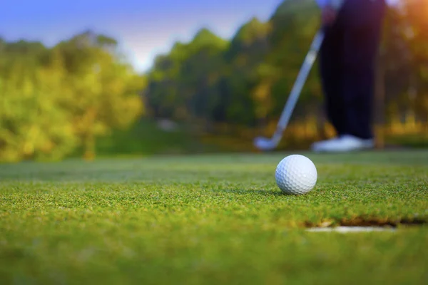 Suddig golfare spelar golf på kvällen golfbana, på solen s — Stockfoto