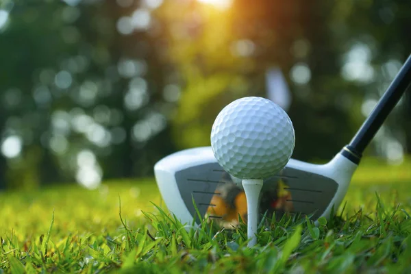 Golf club offuscata e pallina da golf da vicino nel campo di erba con il sole — Foto Stock