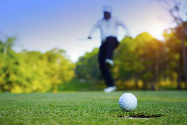 Θολή παίχτης του γκολφ παίζει γκολφ στο βραδινό γήπεδο του γκολφ, στον ήλιο s — Φωτογραφία Αρχείου