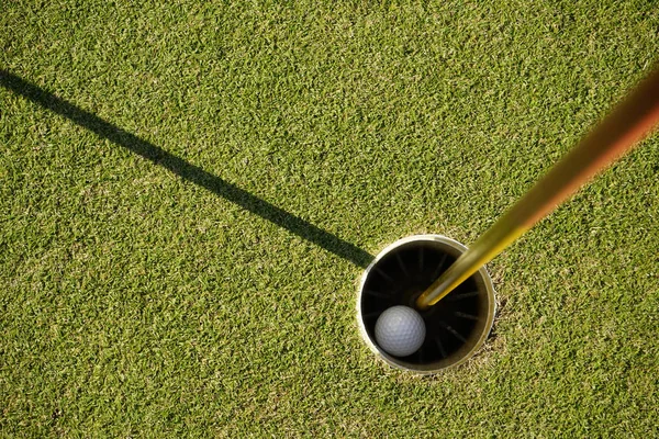 Golfbal in het gat — Stockfoto