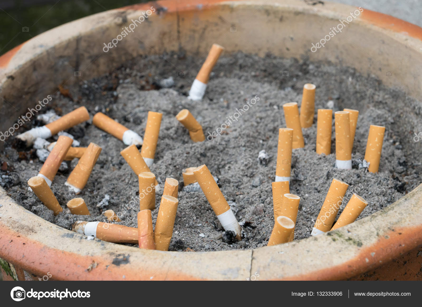 Outdoor ashtray with sand and cigarettes — Stock Photo © JGade 132333906