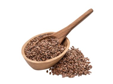 Keten tohumu ya da keten tohumu küçük bir oval ahşap kasenin içinde bir kaşık ve yanına istiflenmiş. Önden ve yukarıdan eğik ve beyaz arka planda izole bir şekilde görünüyor.