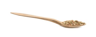 Tahta bir kaşıkta yeşil karabuğday yan görünür ve beyaz arka planda izole edilir.