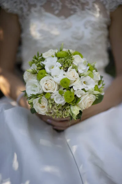 A noiva em um vestido branco segura um belo buquê de rosas brancas delicadas — Fotografia de Stock