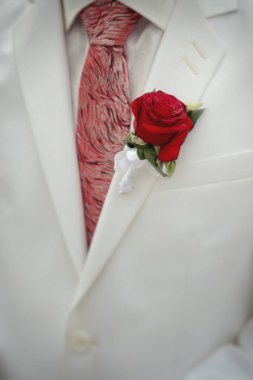 Beyaz ceketli damat, tomurcuklu, kırmızı gül.