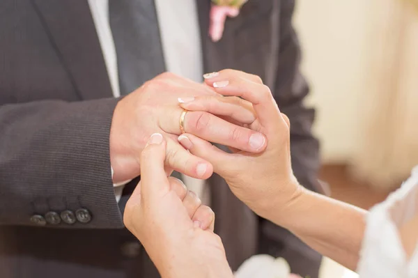 A noiva coloca o anel no dedo do noivo — Fotografia de Stock