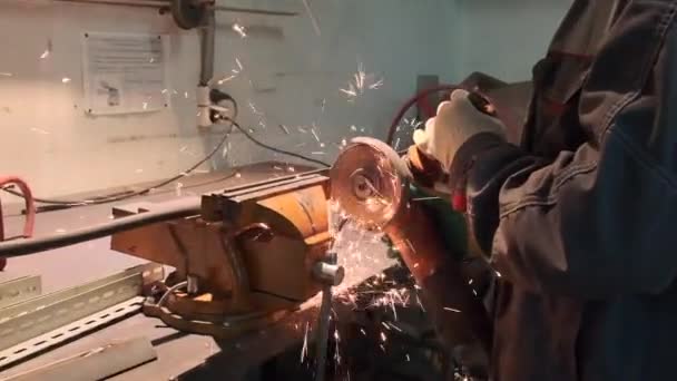 Человек режет деталь, закрепленную в тисках станком для резки — стоковое видео