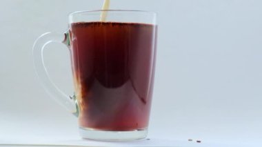 Bardağa sütlü kahve eklendi, yavaş çekimde.