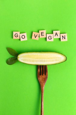 Mektuplar vejetaryen vejetaryen sağlıklı eko salatalıklar yeşil arka planda tahta bir çatalda