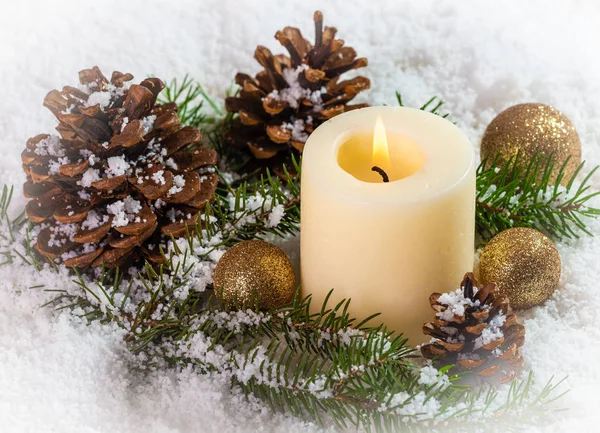 Escena nevada con vela y decoración navideña —  Fotos de Stock
