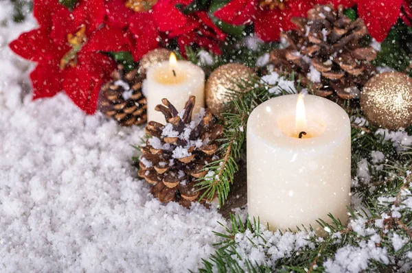 Escena nevada con velas y decoración navideña —  Fotos de Stock