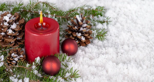 Burning Candle and Holiday Decor on Snow — Stock Photo, Image