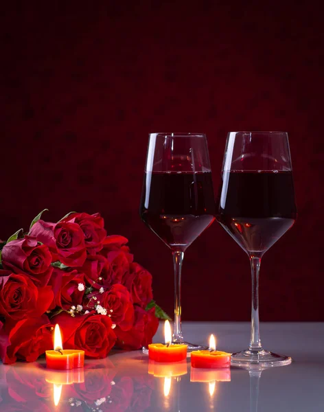 Μπουκέτο με κόκκινα τριαντάφυλλα και ποτήρια κρασί — Φωτογραφία Αρχείου