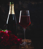Sklenice vína a kytice růží