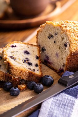 Dilimlenmiş yaban mersini dilimlenmiş bir somun taze böğürtlenli tatlı ekmeğin ahşap kesim tahtasına yakın çekimi