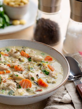 Bir kase kremalı tavuk ve havuçlu ve maydanozlu riice çorbası.