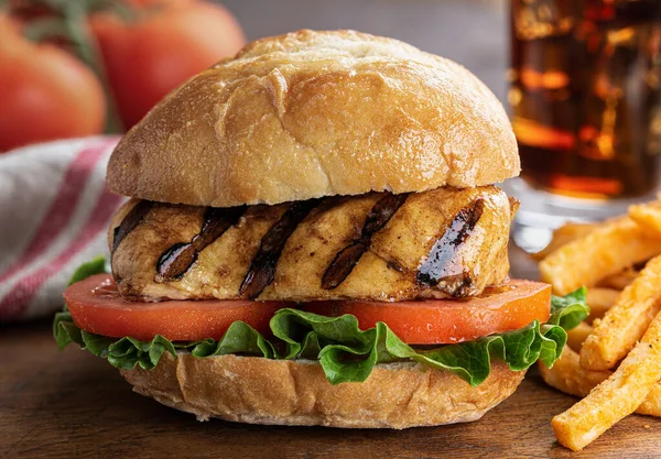 烤鸡胸肉三明治与西红柿和生菜放在乡村木料切菜板上的面包上 — 图库照片