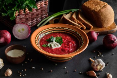 Siyah zemin üzerinde çorba çorbası, kilden bir tabakta.