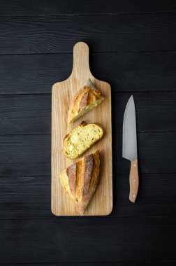 Tahtadaki ekmek, siyah arka planda bir bıçakla