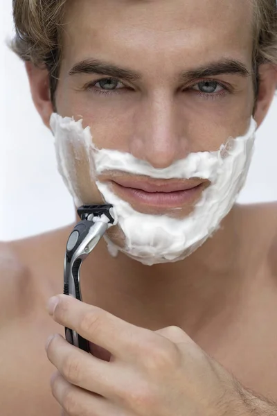 Junger Mann rasiert Gesicht — Stockfoto