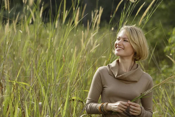 Junge Frau steht auf Feld — Stockfoto