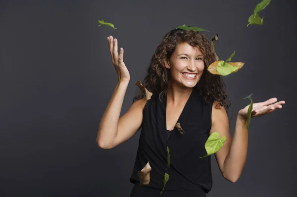 Woman with leaves falling over her — Stock Photo, Image