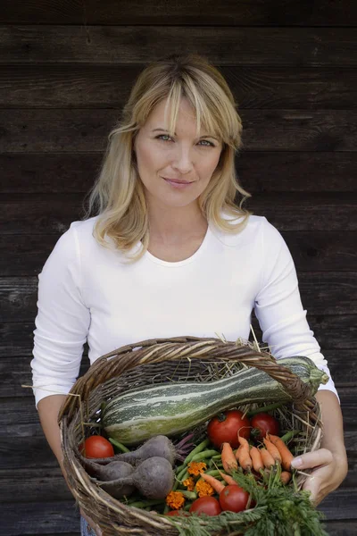 Woman with basket of vegetables — Stock Photo, Image