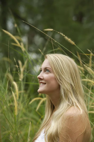 Blonde vrouw in veld glimlachen — Stockfoto
