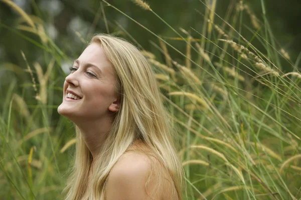 Blonde vrouw in veld lachen — Stockfoto