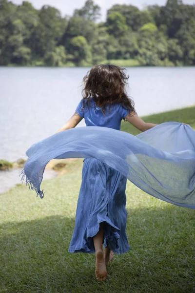 Adolescente chica corriendo por el lago — Foto de Stock