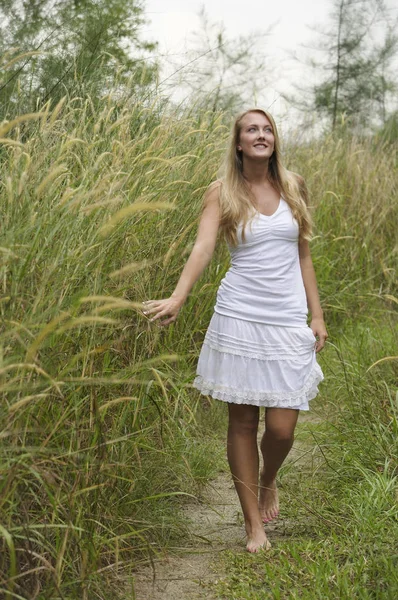 Blonde vrouw op de met gras begroeide pad — Stockfoto
